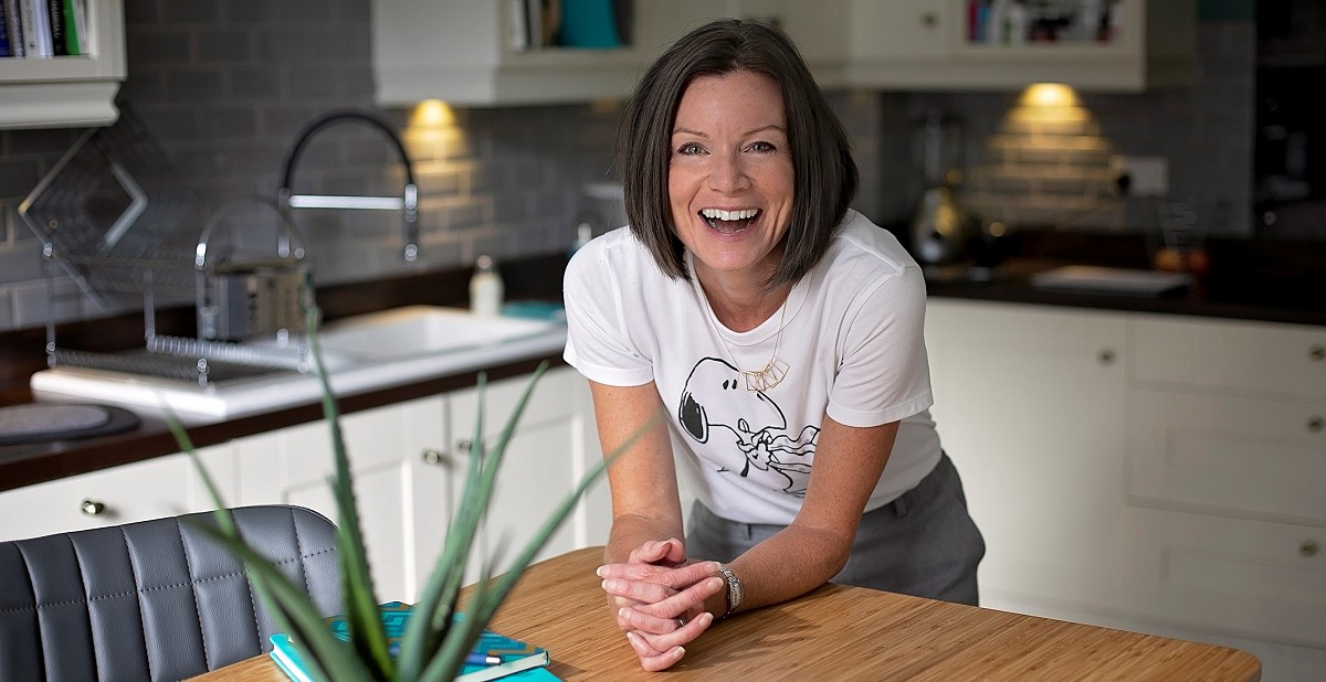 Sarah smiling and leaning on table